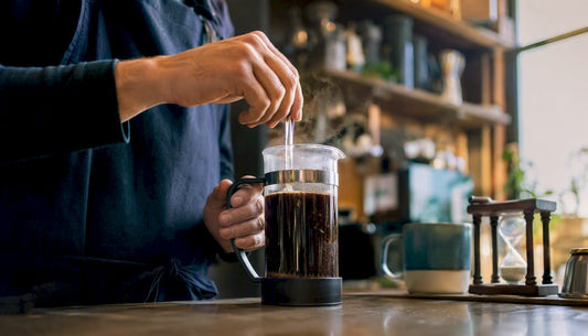 Pouring hot water over coarsely ground coffee in French press