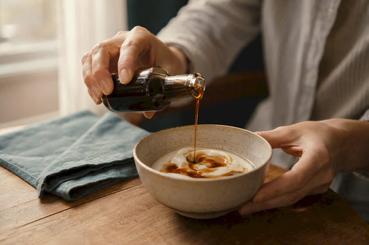 Hands pouring coffee syrup into coffee cup