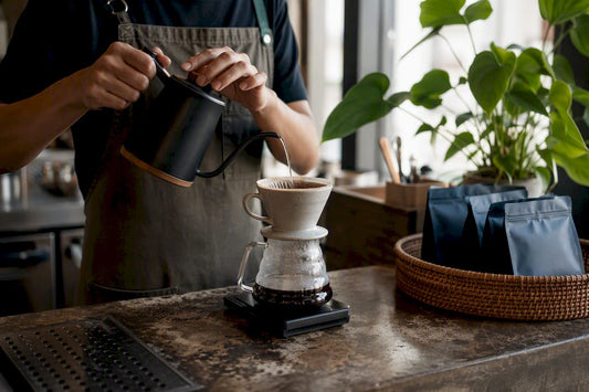 Hands pouring water over coffee grounds